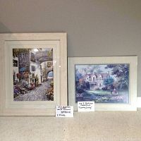 Both framed prints side by side on floor with note cards showing title and framing details