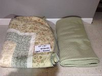 Folded quilt and blanket side by side on floor with size note showing 64 x 85 inches for the quilt