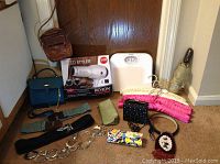 Lot of ladies accessories including purses, belts, a hairdryer, an umbrella, padded hangers, and a white platform scale.