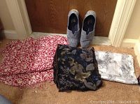 Photo showing three scarves of different patterns and one pair of grey slip-on shoes