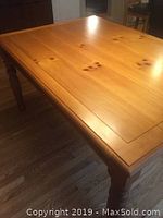 Rectangular pine dining table with visible wood grain and knots on surface.
