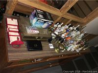 Image showing assorted bells in brass, glass, and china along with jewelry box, jewelry cleaner box, and small black case on wooden table.