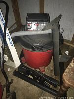 Photo showing the full vacuum unit with hose and various attachments on the floor.