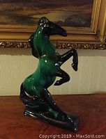 Front view showing the rearing stallion with green and black coloring and glossy finish.