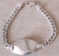 Front view of sterling silver Medic ID alert bracelet showing oval plate with raised caduceus symbol and flat link chain.