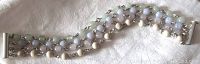 Full view of the bracelet showing multi-strand beads in pale colors with a tubular silver clasp.