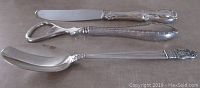 Top view showing knife, bottle opener, and spoon with clear detail of handles and blade/spoon surfaces.
