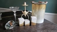 Photo of assorted candle holders and glass pieces on wooden surface