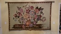 Front view of large rectangular Italian tapestry with floral design and hanging rod.