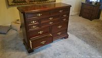 Front view of dark wood dresser with several drawers, one open.