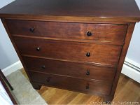 Front-facing view showing four drawers and cherry finish