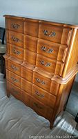 Front angled view of Kent Coffey tall dresser showing scalloped drawer fronts and brass handles.