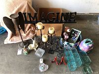 View showing entire lot with candle sticks, IMAGINE sign, crystal dish, votives, ceramic hatboxes, and metal decorative pieces.