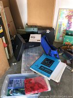 Wide view of crafting supplies including art board, blue bag, XL Mixed Media sketchbook, clear containers, and black photo box.