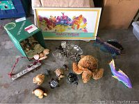 14-piece lot showing framed colorful Tracy Taylor marine print, metal and wooden fish sculptures, glass seashell bowl, turtle figurines, dolphin figurines, and seashells in original box.