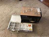 Photo showing 6 Buckingham cordial glasses with 24K gold rims in box, and 3 Luminarc wine tumblers in front of their box