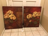 Two canvas prints showing yellow flower clusters in a brown vase on warm brown backgrounds.