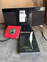 Panasonic iPod dock with Kanye West CD and Stevie Nicks DVD shown on floor.