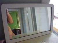 Front view of the rectangular mirror showing the full wood frame and reflective glass surface.