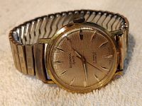 Front view of the Rodania Sport wristwatch showing gold tone textured dial, applied hour markers, and metal expandable bracelet.