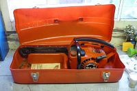 Orange HomeLite carry case open with XL2 chainsaw inside, showing latch mechanisms and general condition.