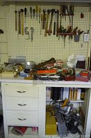 Overall shot of the work area showing pegboard and countertop with tools and vintage items arranged for inventory and condition assessment.