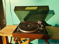 Front angled shot of the Dual 502 turntable showing wooden base, platter, tonearm without needle or head, and transparent dust cover.