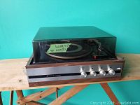 Front view of the Fleetwood record player with glass dust cover on, showing control knobs and brand name.