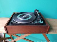 Front-left angle showing full turntable, platter, tonearm, and wooden case.