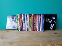 Photo of 17 DVDs in cases, showing titles and condition, with some thrift store stickers.