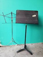 Photo of the Manhasset black metal music stand showing the solid desk with brand name and tripod base.
