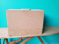 Closed beige carrying case for Brother Prestige travel sewing machine showing some wear and scuff marks.