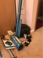 Photo showing Canon camera, tripods in boxes, filters case, and accessories grouped on carpeted floor