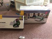 Two boxed items on carpet: Xyron 9" Creative Station Laminator and refill cartridge.