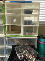 Clear plastic storage drawers used for organizing jewelry making supplies, one drawer missing, some drawers contain small containers and craft items.