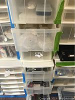 Stacked translucent plastic storage units with multiple open drawers revealing contents inside including beads and crafting supplies.