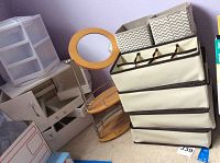Photo of multiple storage items including plastic drawers, fabric drawers, small fabric bins, and round vanity mirror with trays.