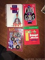 Top down photo of all four books laid out on a table: The Klutz Book of Magic, The Best Card Games in the Galaxy, Boys Know It All, and Stop The Watch.