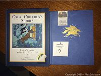 Two hardcover children's literature books displayed on a wooden surface. One titled 'Great Children's Stories - The Classic Volland Edition' and the other 'A Treasury of Children's Literature' with gold Pegasus emblem on front.