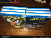 Six Hardy Boys hardcover books stacked together, wrapped in original plastic packaging, showing spines and tops.