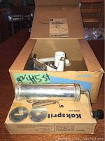 Old metal portable meat grinder and food chopper set in original box with instructions, hand crank visible