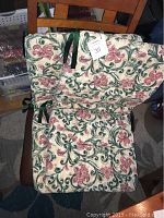 Two floral printed lawn chair cushions stacked, showing pattern and attached ties