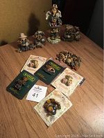 Overview of figurines, pins, and book laid on wooden surface.