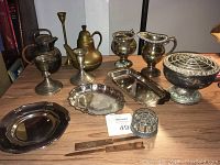 Wide view of collection showing trays, candlesticks, flower frog, tea pots, and sugar/creamer set
