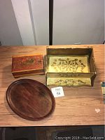Lot of three wooden accessories on a table: handmade wooden shelf, carved wooden box, and Ritter Pressholz oval wooden tray.