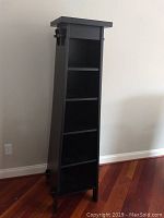 Frontal view of black A-frame shelving unit showing four shelves and minor surface wear.