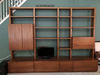 Front view of assembled wall unit showing shelves, desk panel, and drawer modules