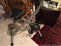 Side view showing the adjustable seat and folding metal frame of the exercise bike.