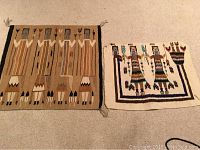 Two Navajo rugs laid flat, showing one with multiple vertical stripes and stylized figure and horse motifs, and the other with two standing Yei figures and a bordered design.