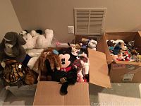 Three boxes filled with assorted plush toys and Beanie Babies, showing variety of sizes and colors